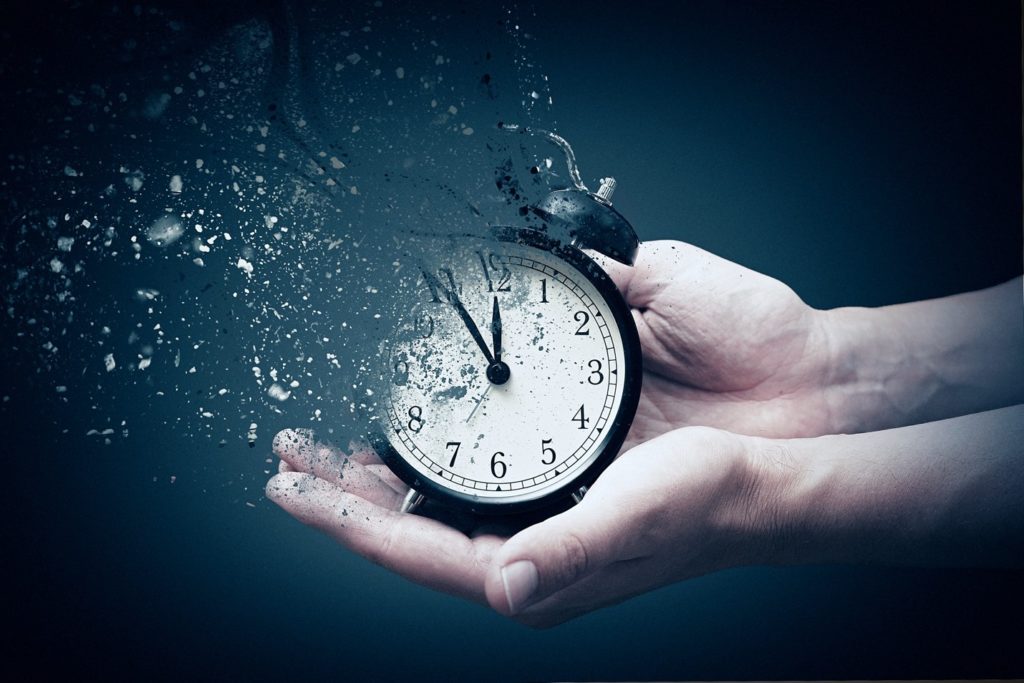 Clock held in two hands dissolving