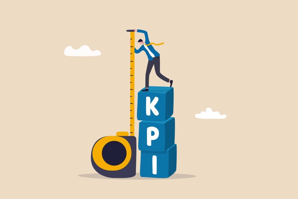 A cartoon man holds a tape measure while standing on top of building blocks with the letters "K", "P", "I"